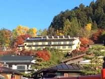 秋、中橋より望む城山の紅葉に囲まれる当館 秋、中橋より望む城山の紅葉に囲まれる当館